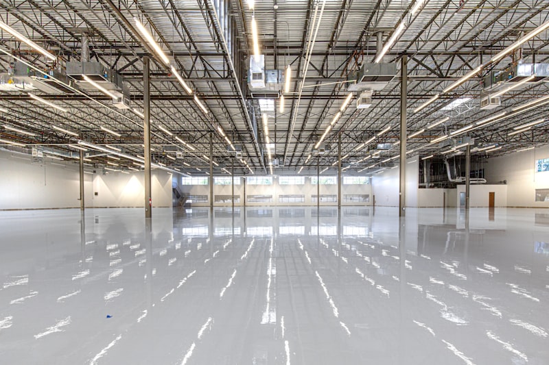 A freshly sealed and polished warehouse floor reflecting the overhead lights.