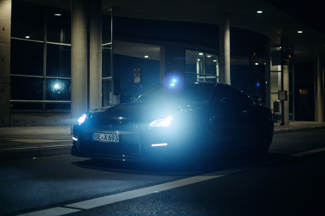 A patrol vehicle with headlights on at night outside a commercial building.