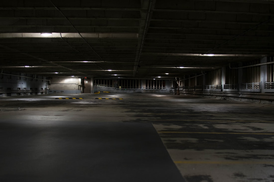 An empty commercial car park at night, the kind of site covered by overnight mobile security patrols.